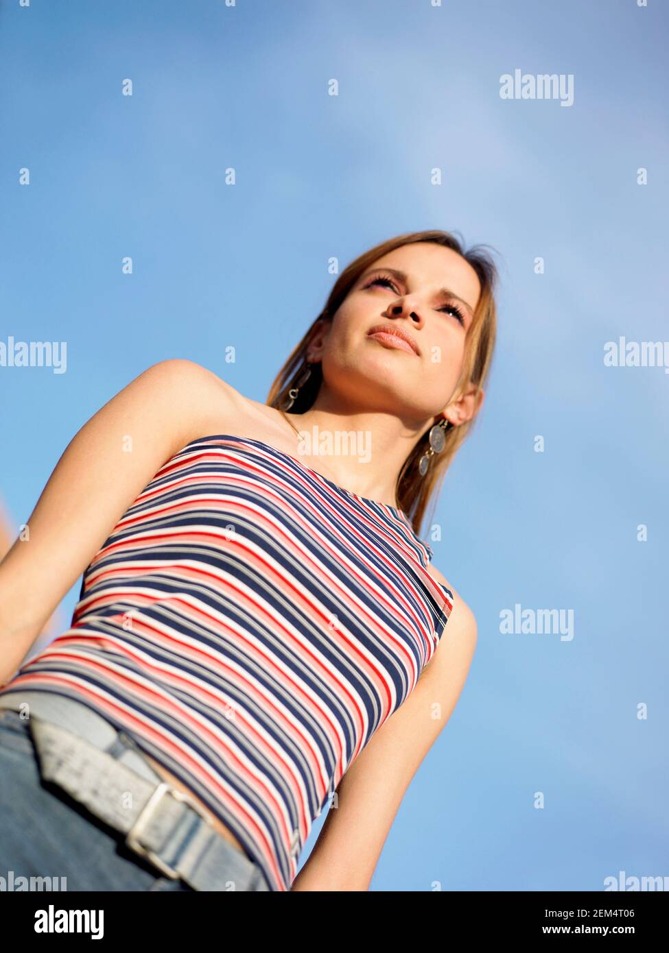Low angle view of a young woman standing and looking away Stock Photo