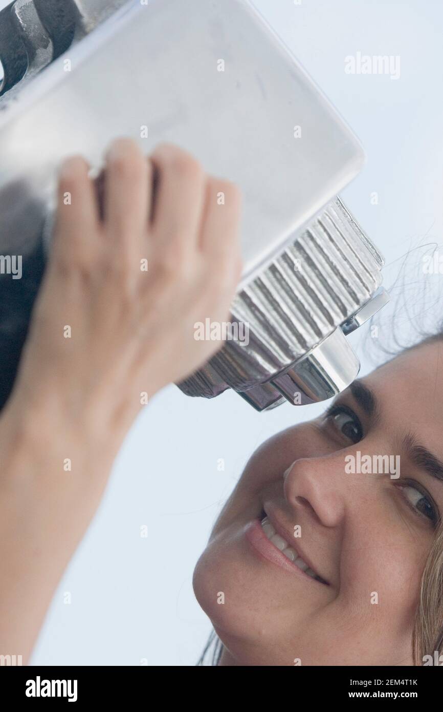 Portrait of a mid adult woman holding a pair of coin-operated binoculars and smiling Stock Photo