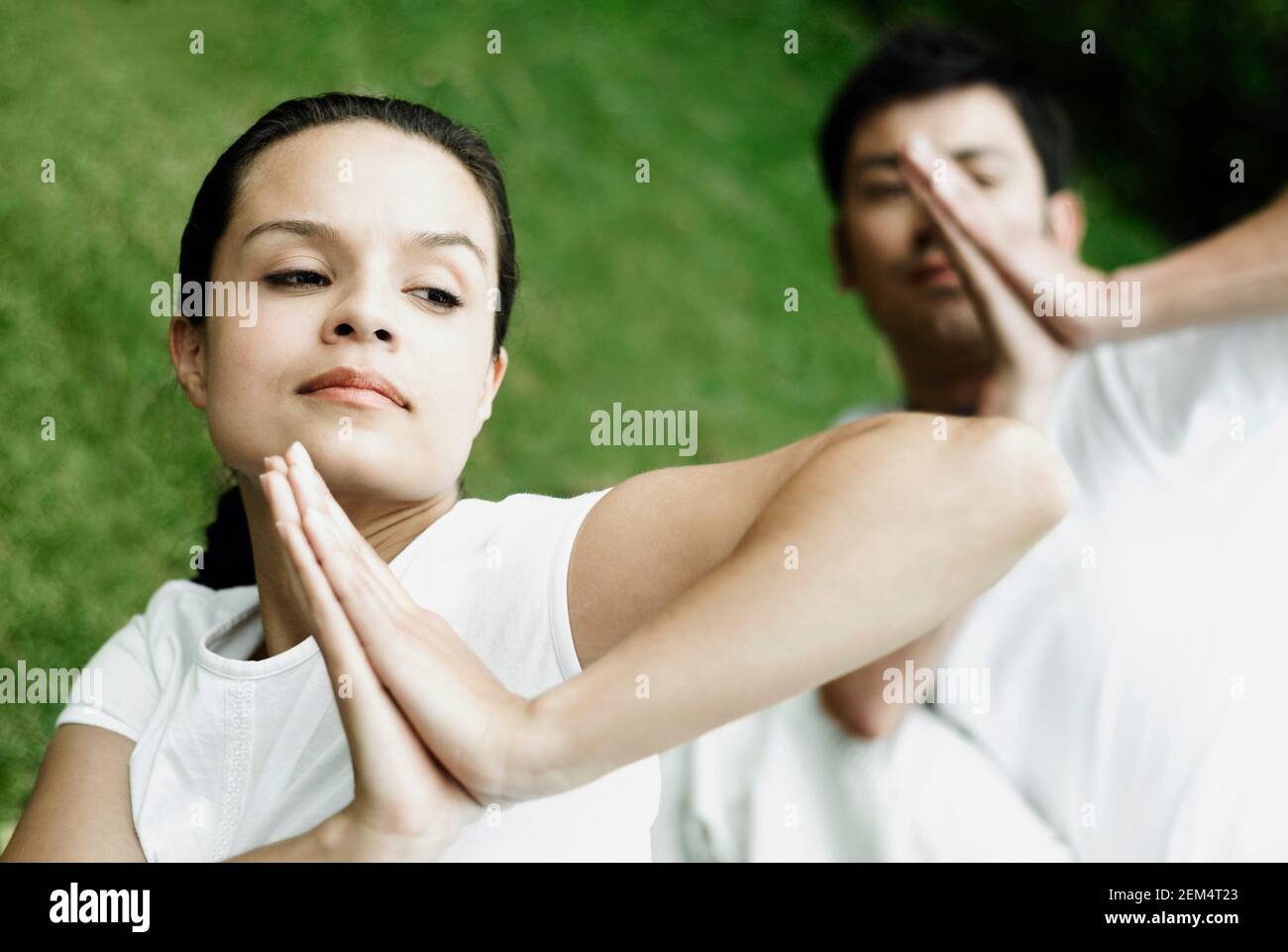 Close-up of a young woman and a young man in a prayer position Stock Photo