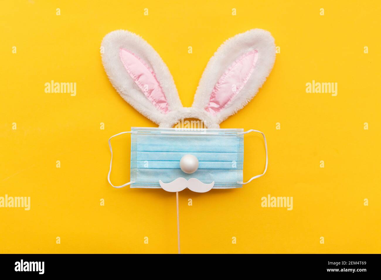 Coronavirus Easter bunny face made from rabbit ears and a protective face mask Stock Photo