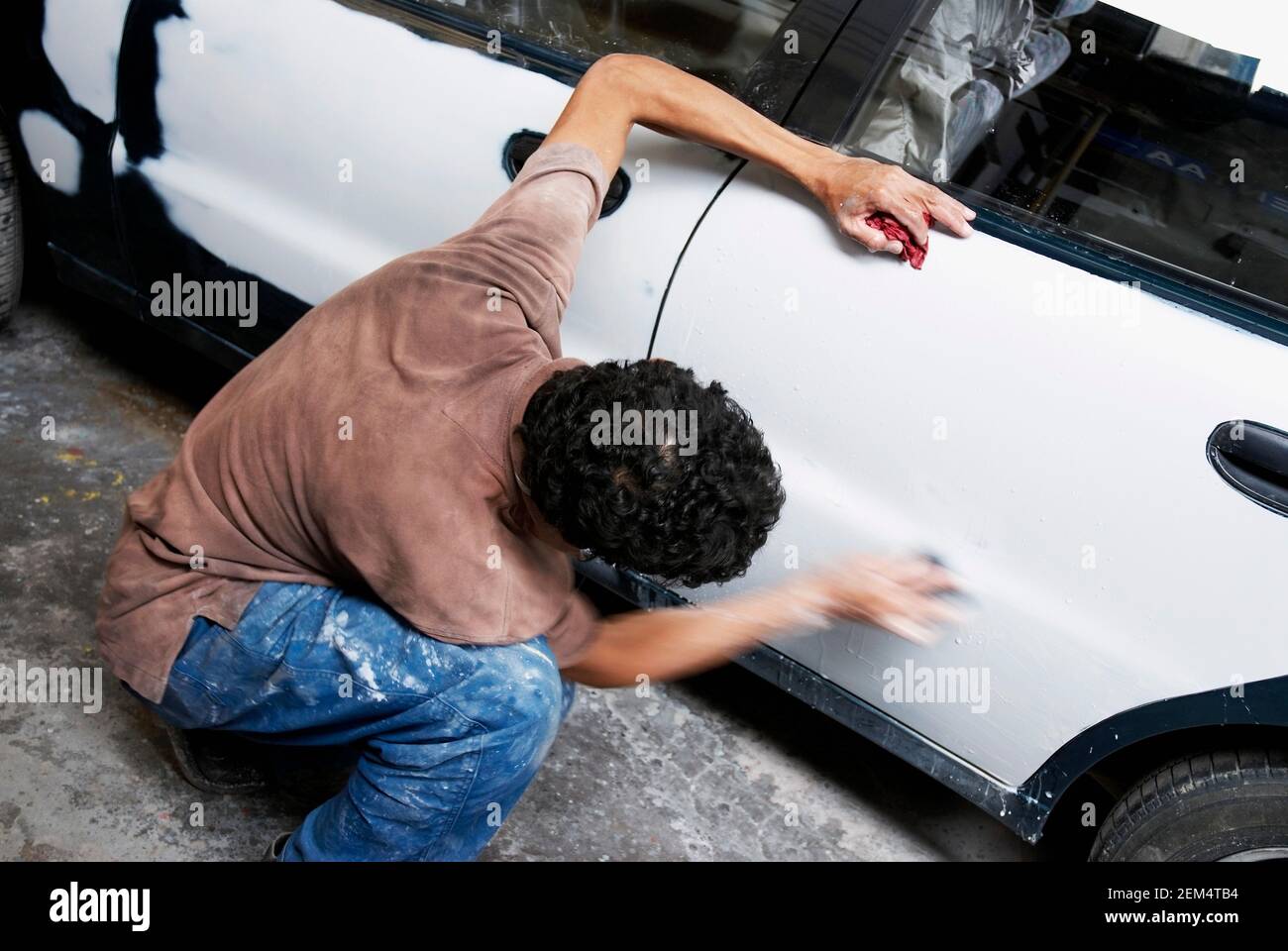 High angle view of a male mechanic polishing a car in a workshop Stock Photo