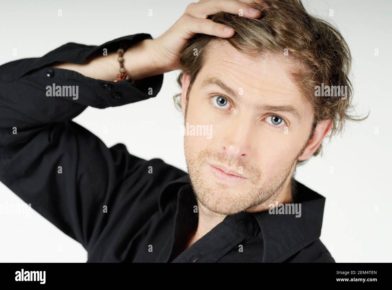 Portrait of a young man with his hand in his hair Stock Photo