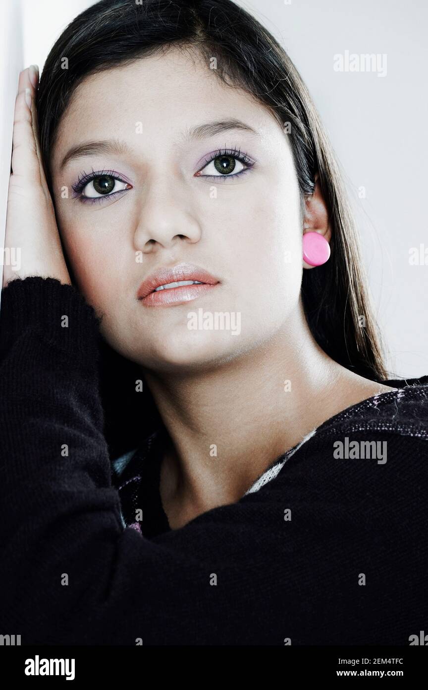 Close-up of a young woman leaning against a wall Stock Photo