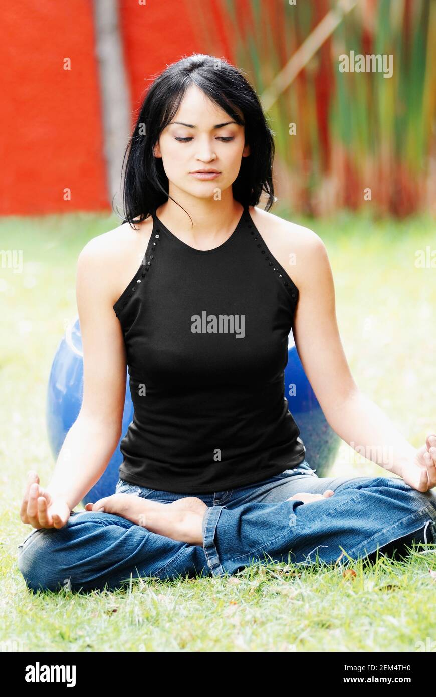 Young woman meditating on a lawn Stock Photo
