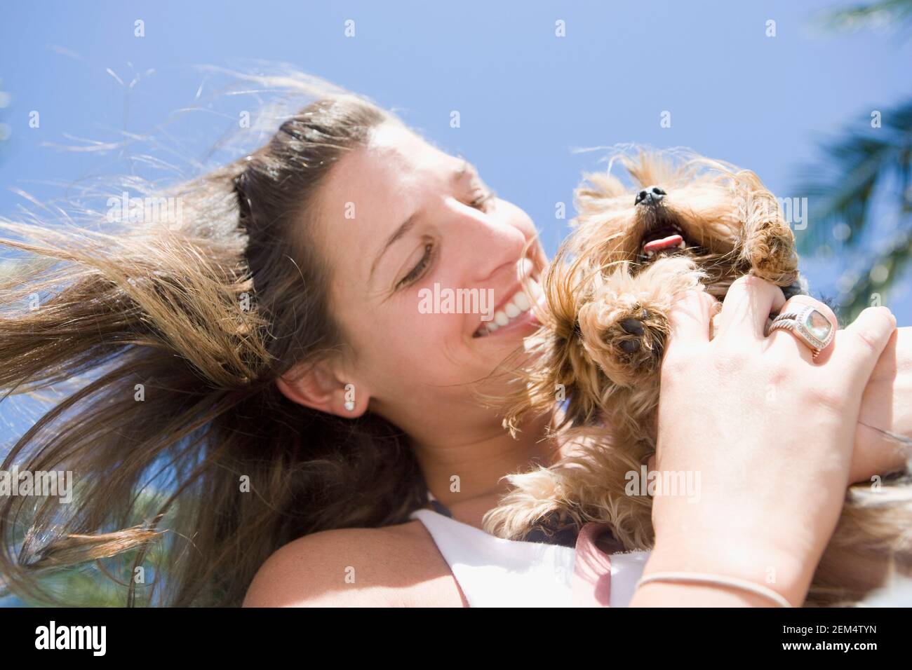 Close-up of a young woman hugging her dog and smiling Stock Photo