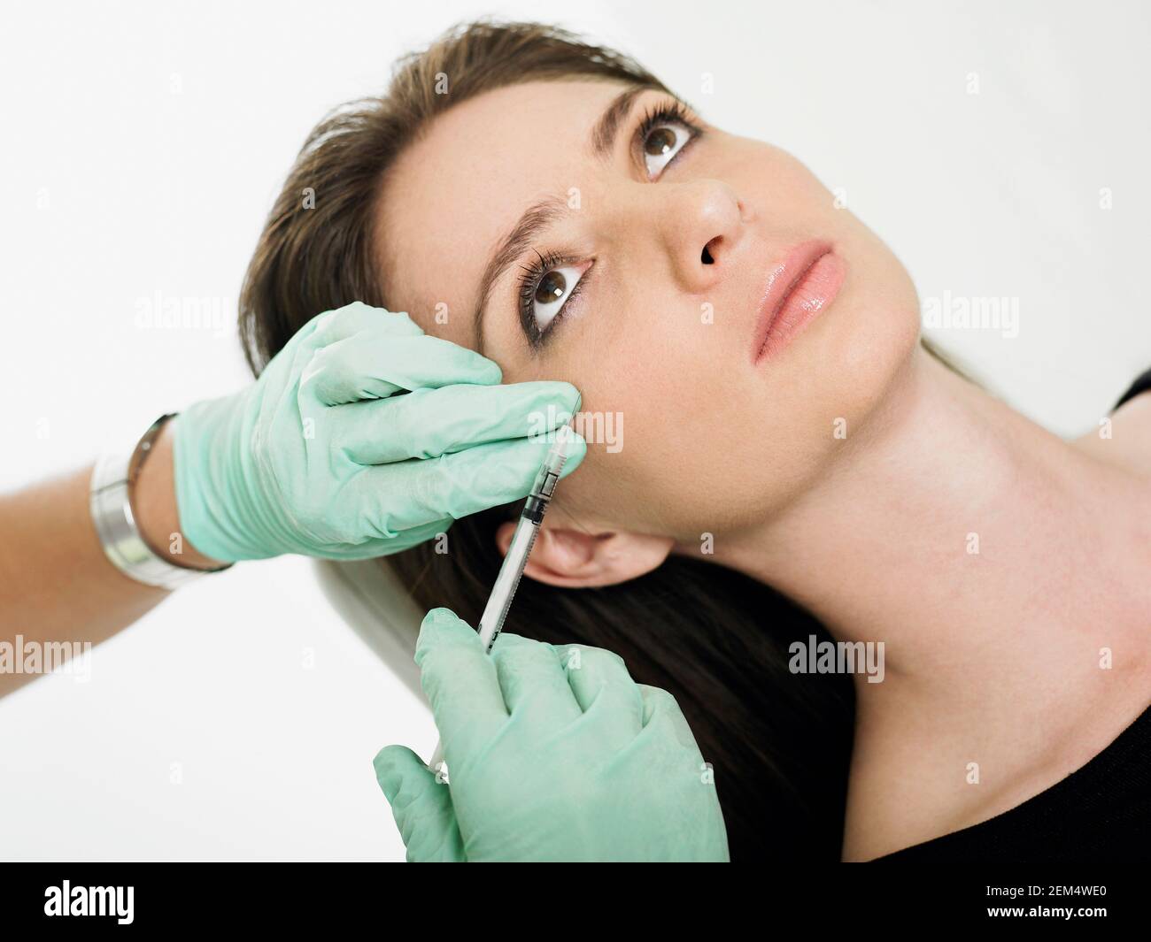 Close-up of a mid adult woman getting a botox injection on her face Stock Photo