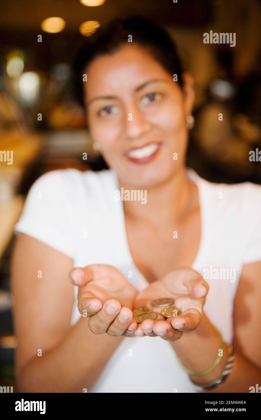 Portrait of a mid adult woman showing coins and smiling Stock Photo