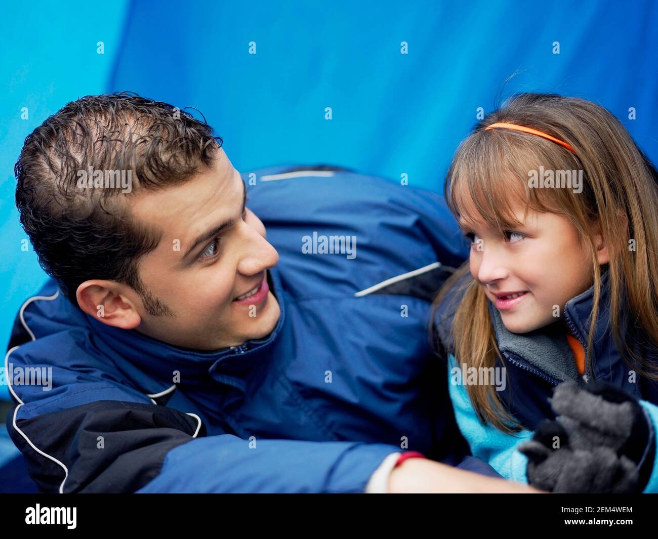Close-up of a young man and his daughter lying in a camping tent Stock Photo