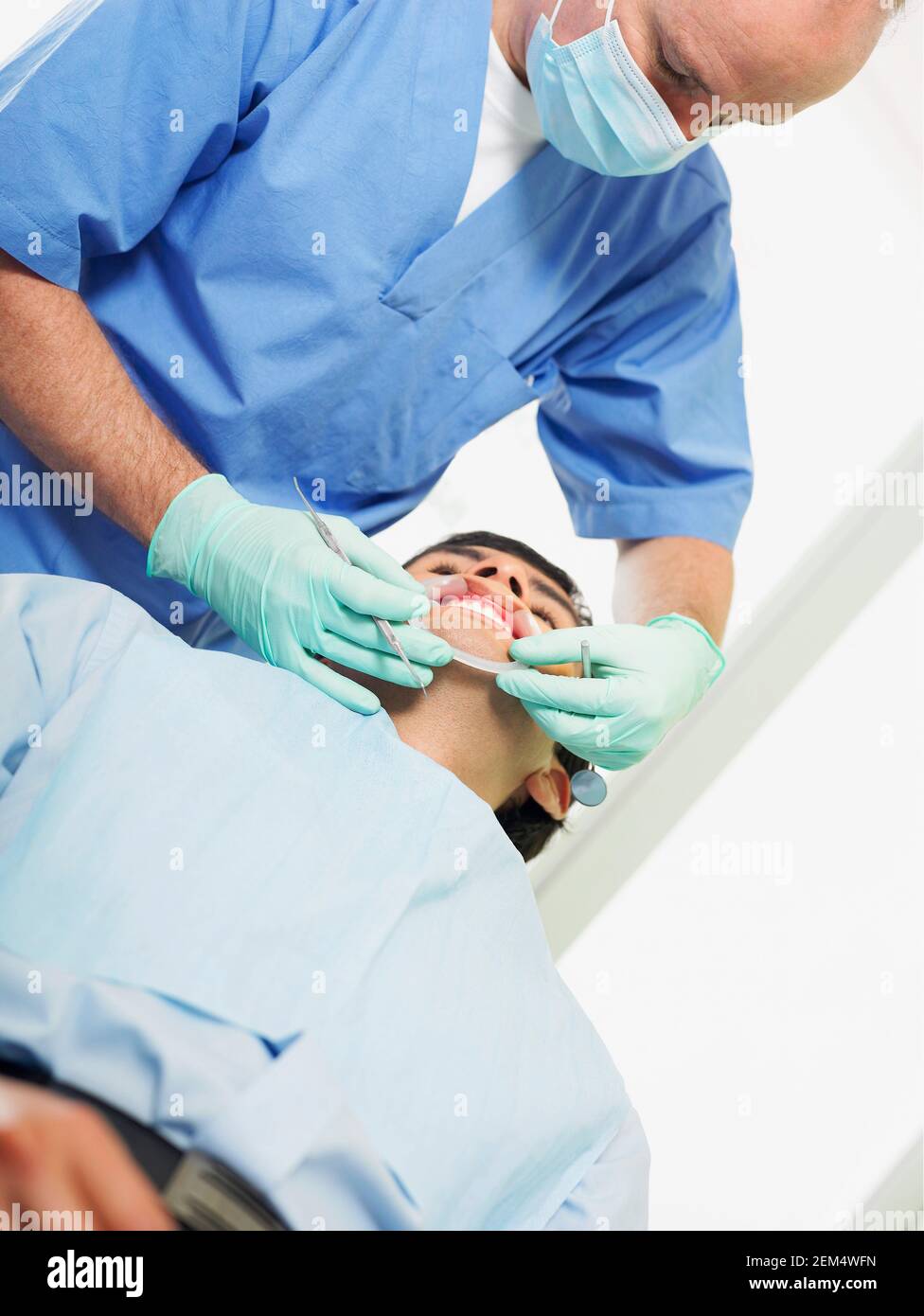 Low angle view of a young man getting his teeth examined by a dentist Stock Photo