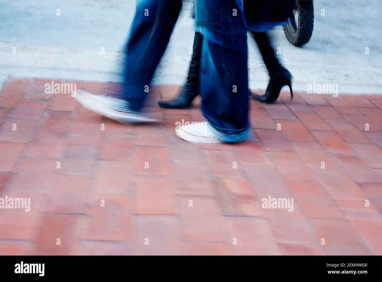 Low section view of a man and a woman walking Stock Photo - Alamy