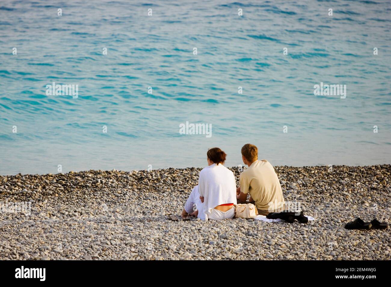 Rear view of a young couple relaxing on the beach Stock Photo