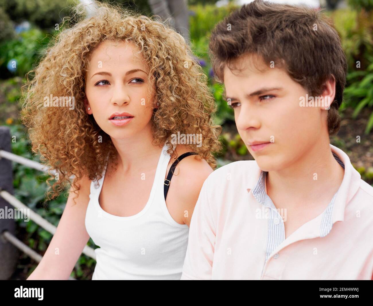 Close-up of a young man thinking with a teenage girl sitting beside her Stock Photo