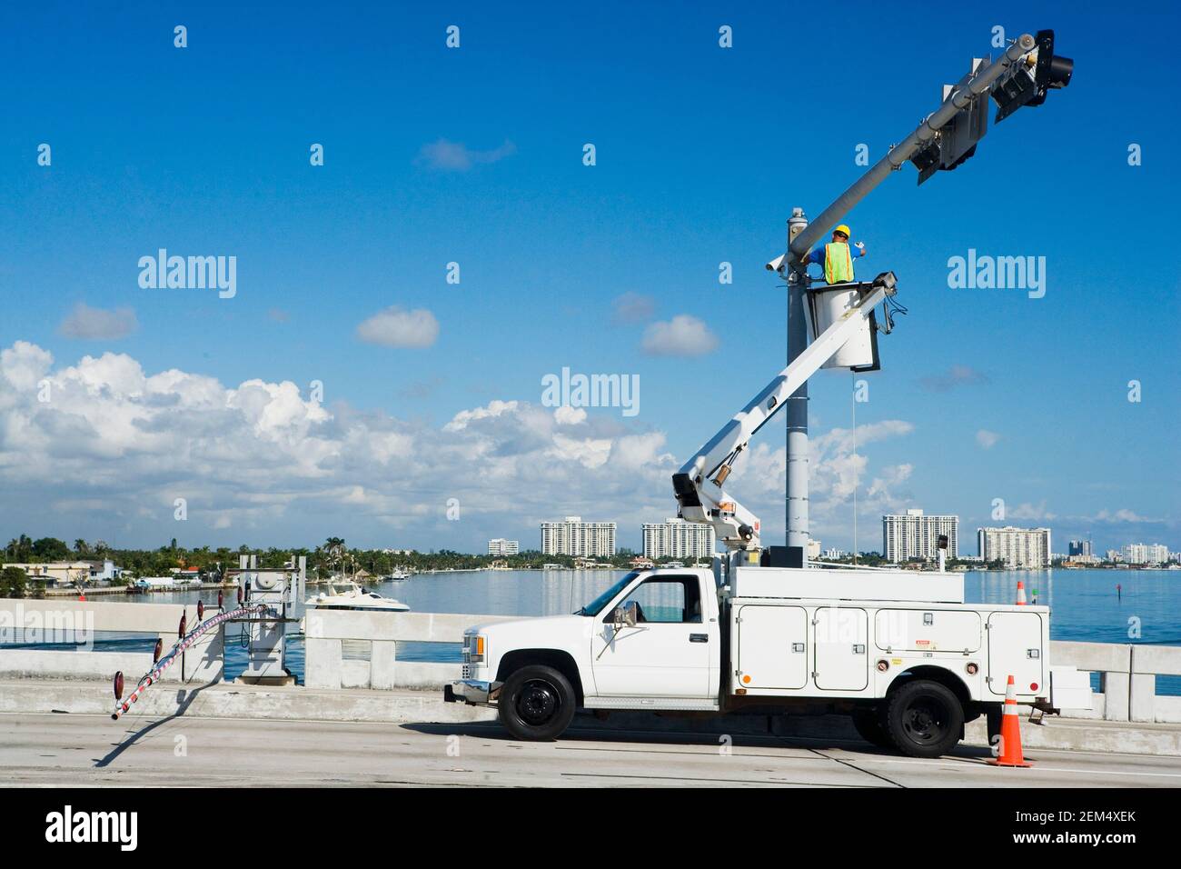Rear view of a maintenance engineer on a mobile crane repairing a