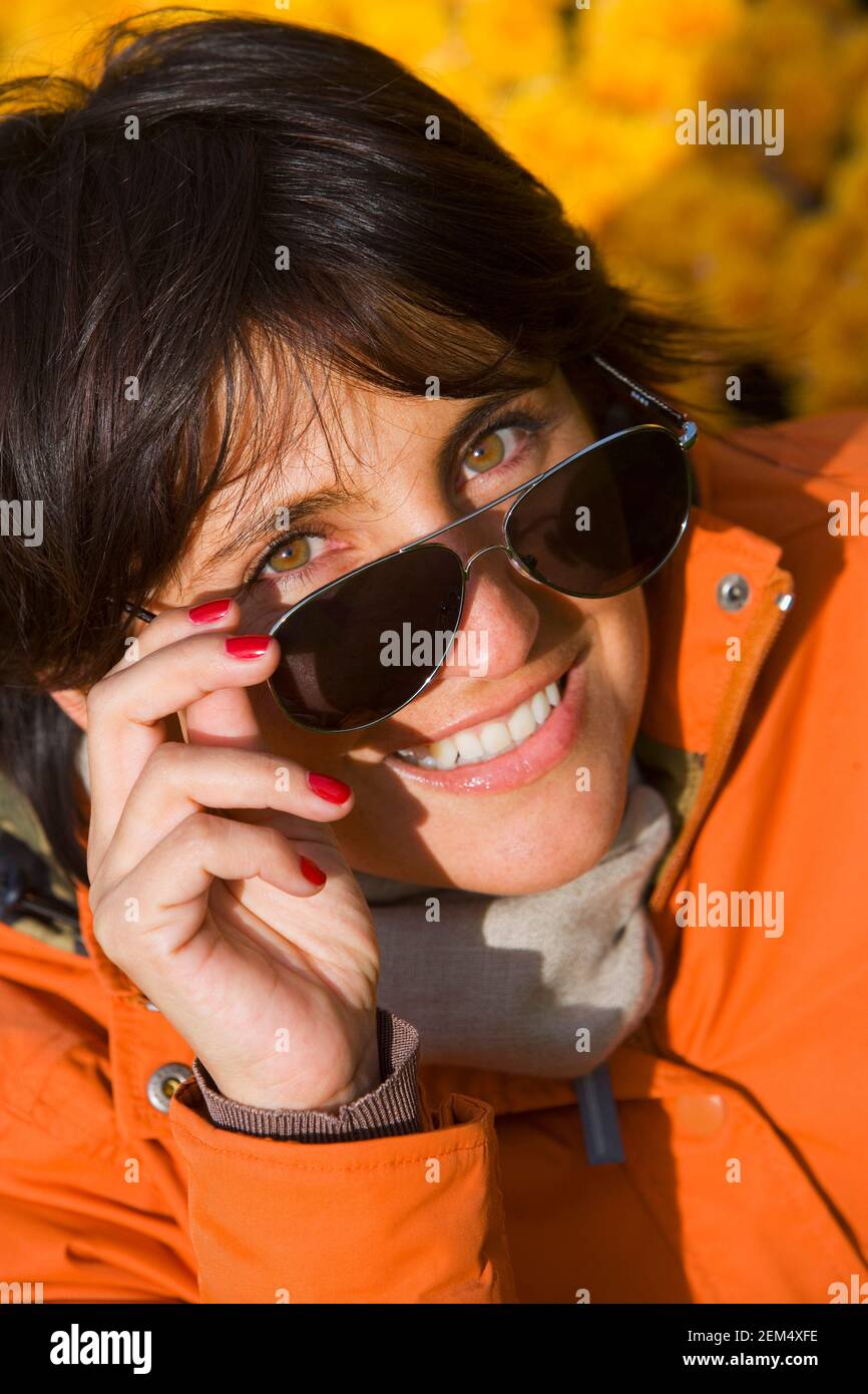Portrait of a mid adult woman peeking over her sunglasses Stock Photo