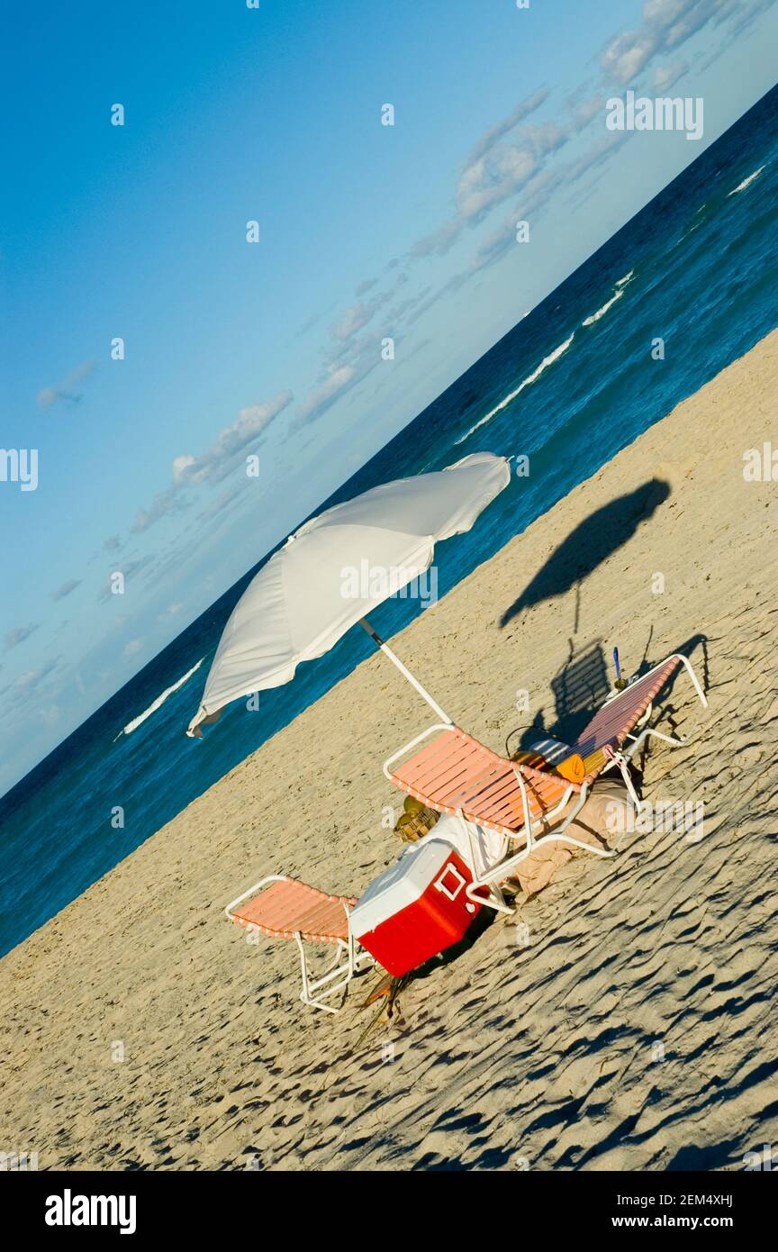 Lounge chairs with a beach umbrella on the beach, Miami, Florida, USA