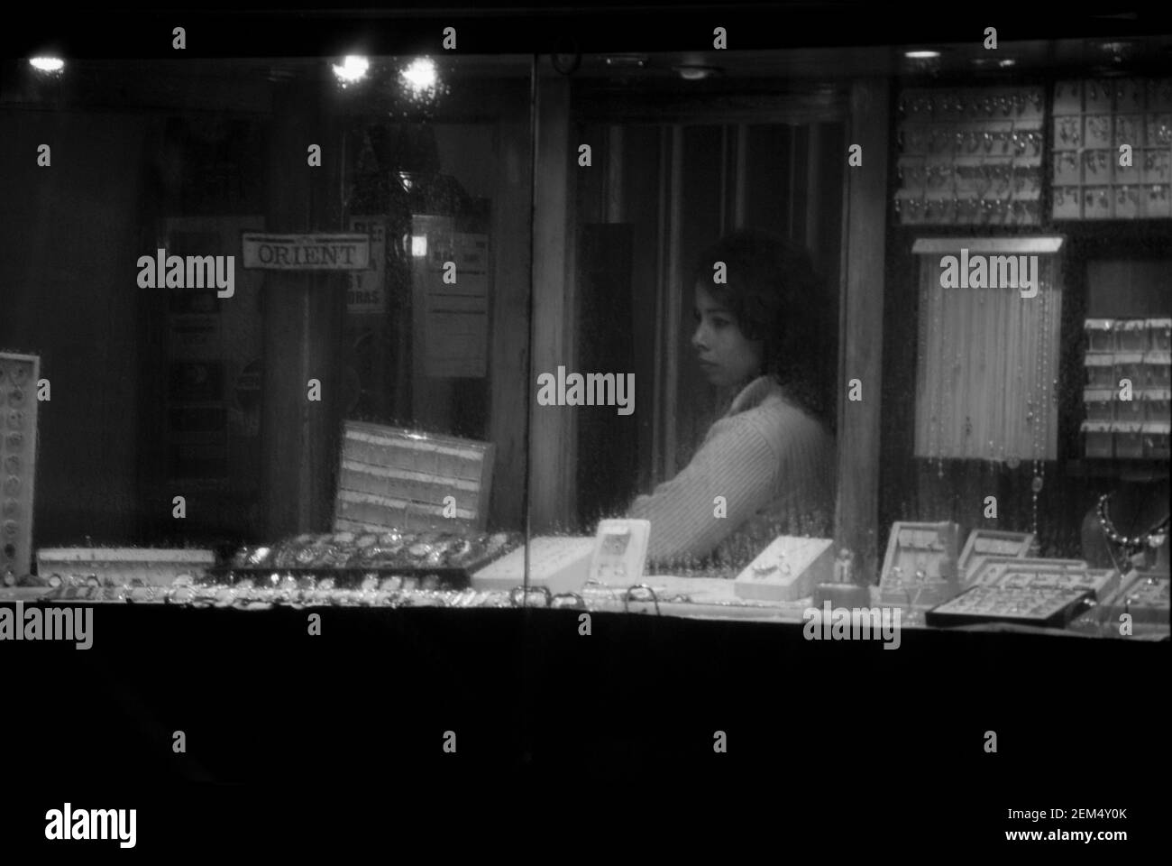 Side profile of a mid adult woman behind a window display of a store Stock Photo