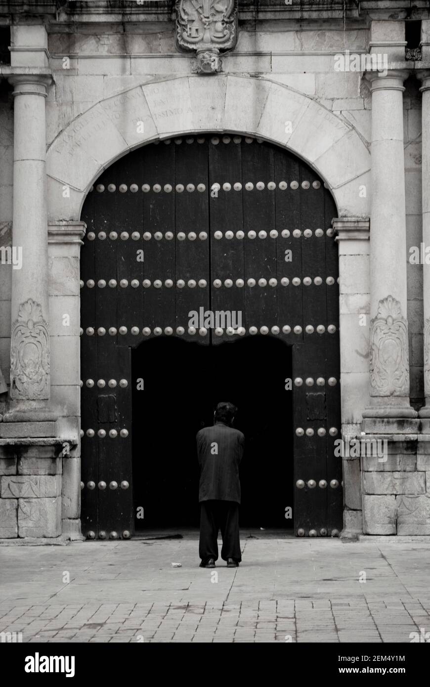 Rear view of a man standing in front of a gate Stock Photo - Alamy