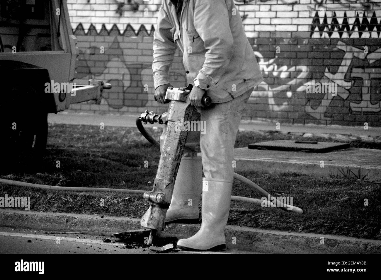 Person using a jack hammer on the road Stock Photo