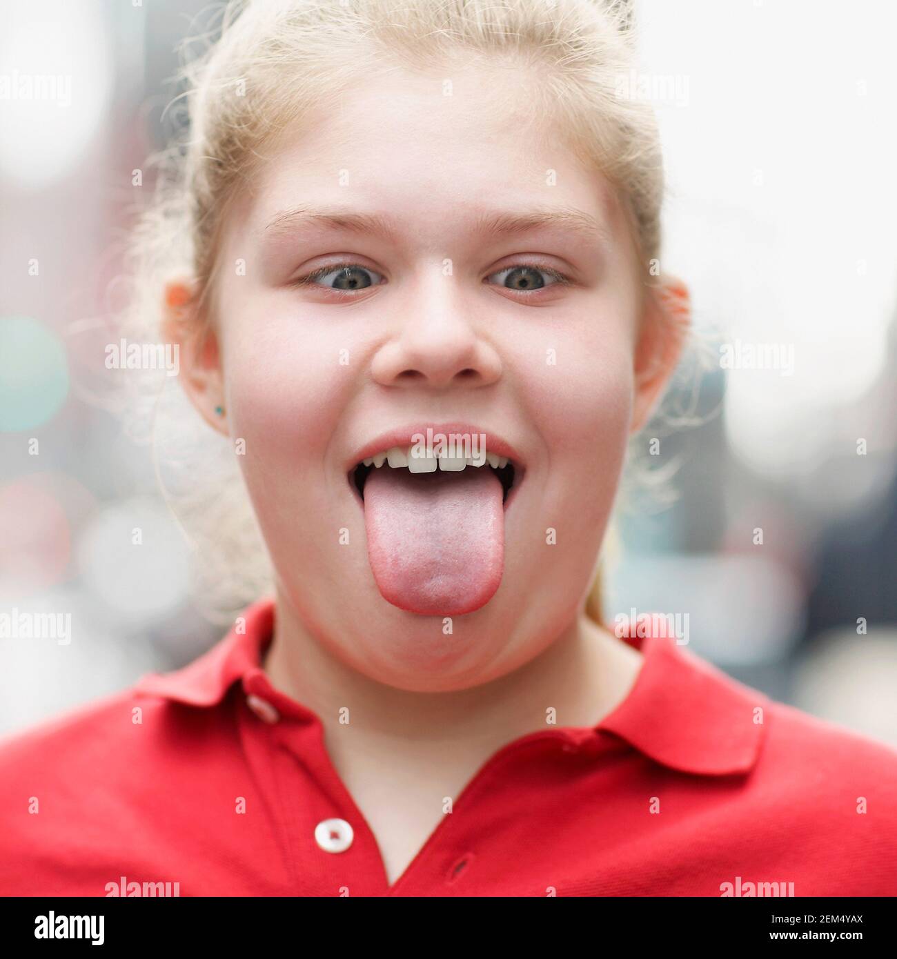 Close-up of a teenage girl sticking out of her tongue Stock Photo