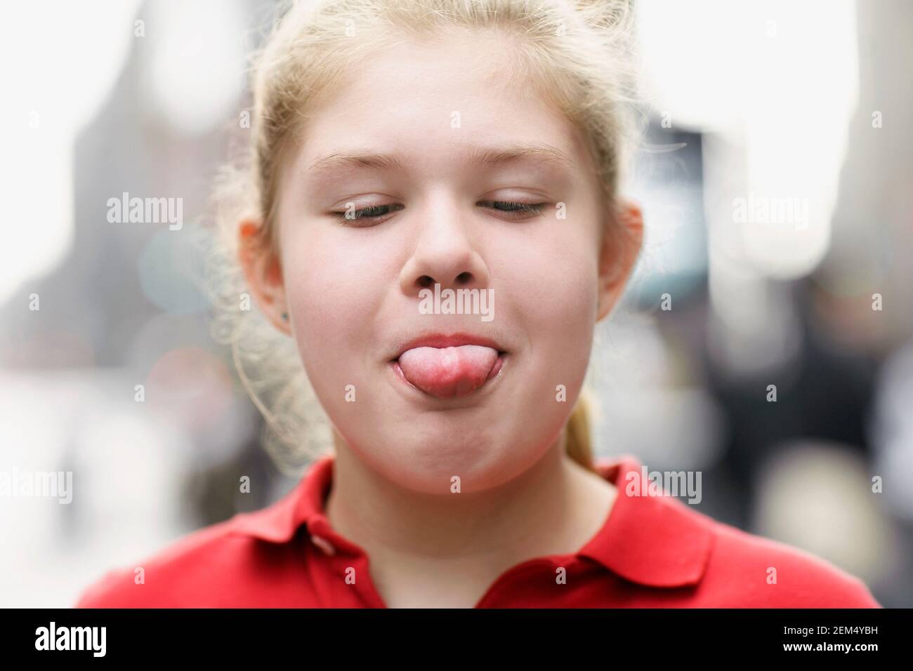 Close-up of a teenage girl sticking out of her tongue Stock Photo