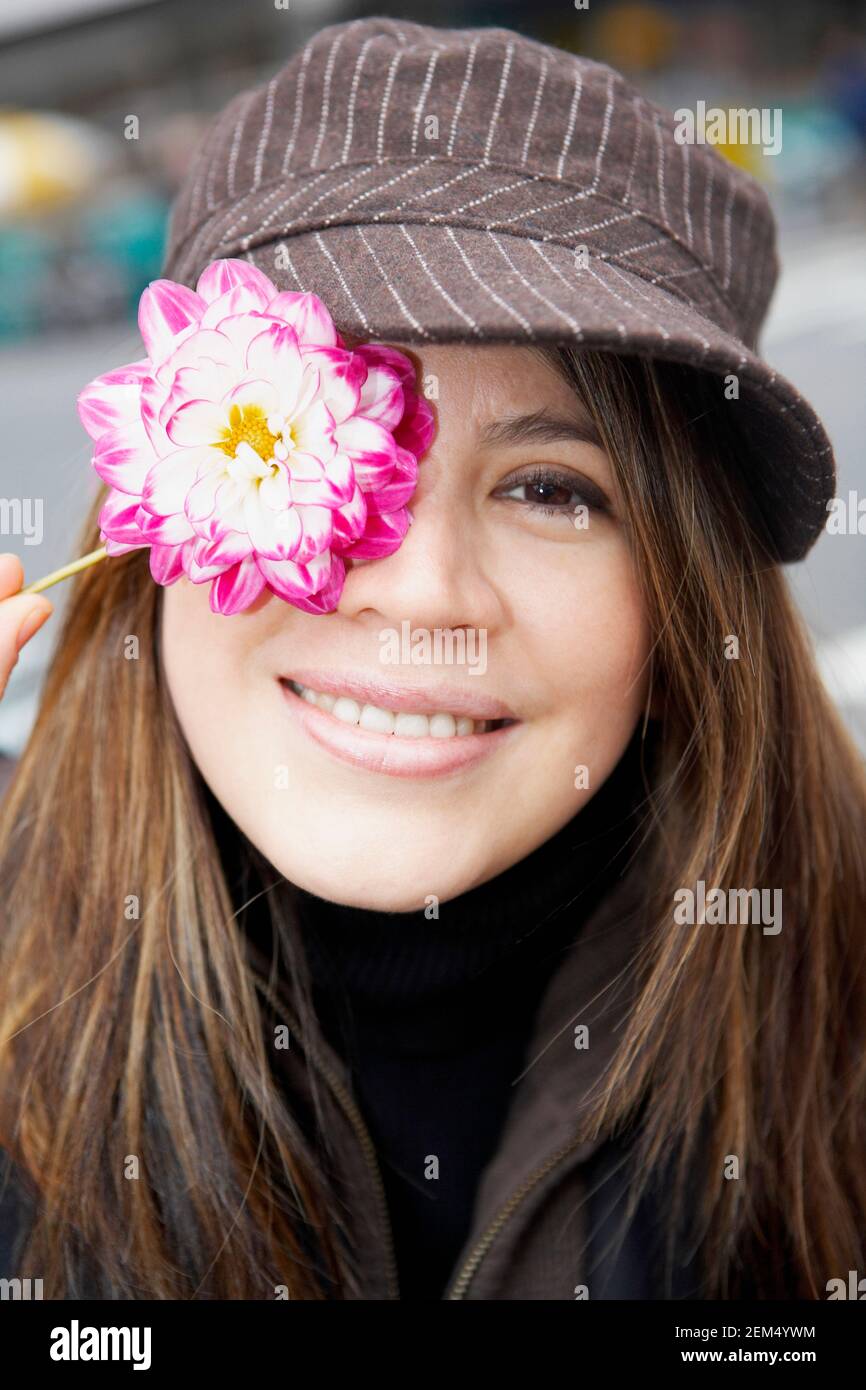 Portrait of a young woman covering his eye with a flower Stock Photo