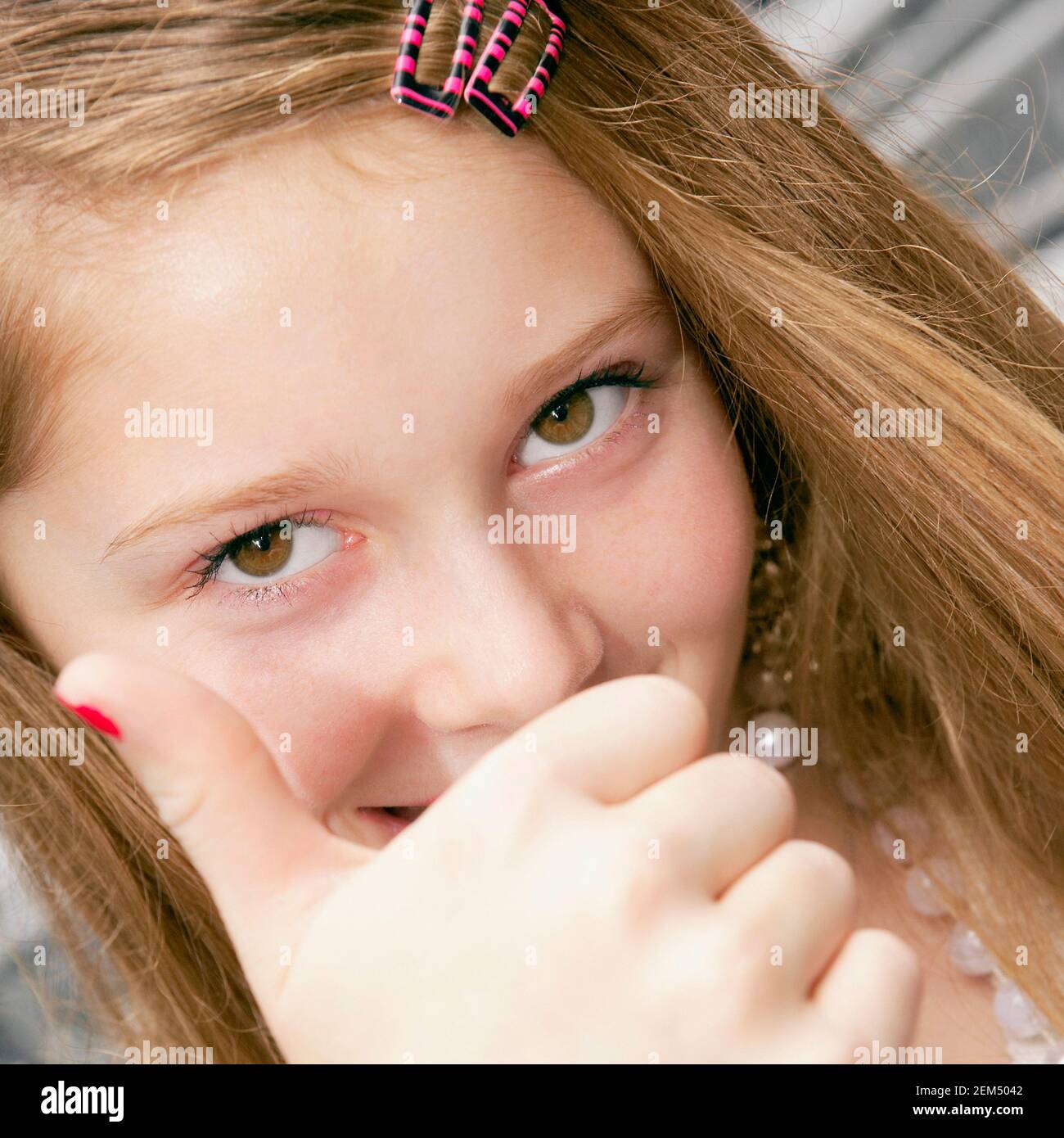 Portrait of a teenage girl covering her mouth with her hand Stock Photo