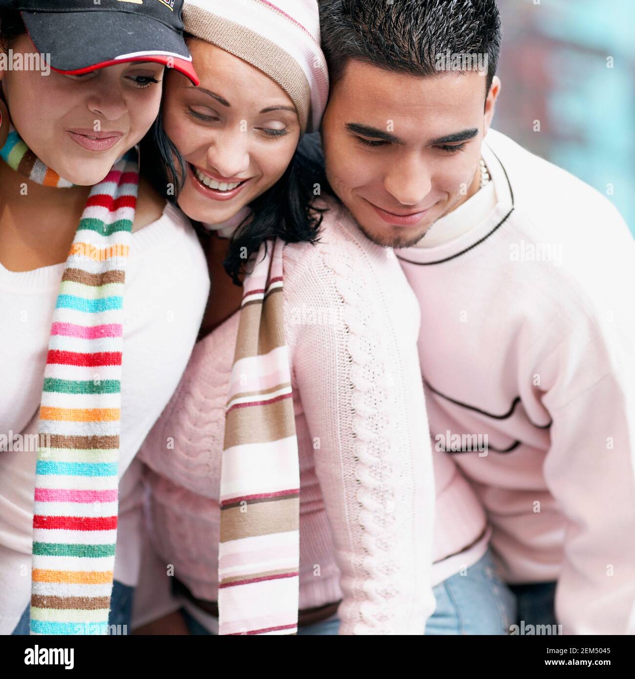 Close-up of two young women and a mid adult man smiling Stock Photo