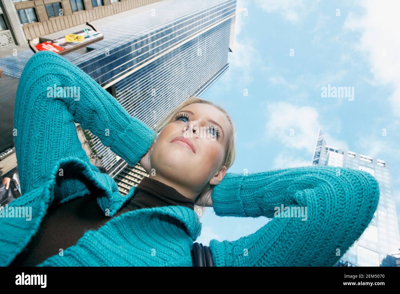 Low angle view of a teenage girl with her hands behind her head Stock
