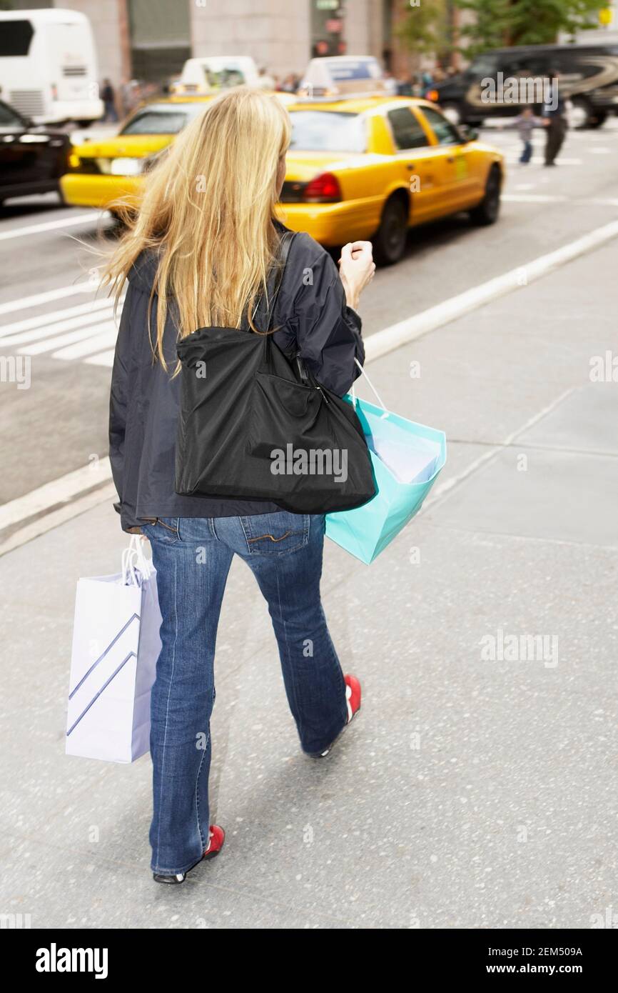 Rear view of a woman walking on the roadside Stock Photo - Alamy