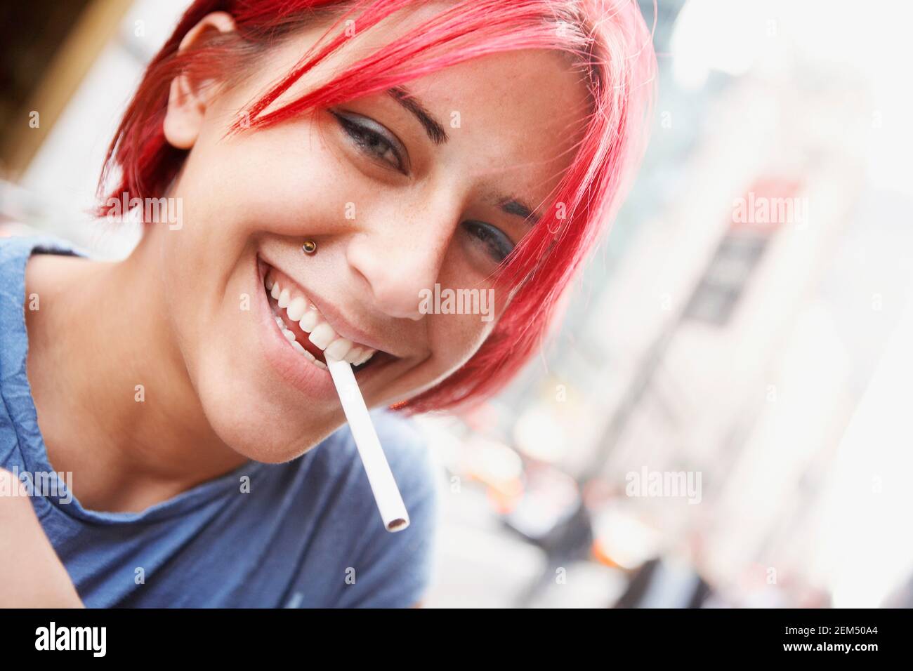 Portrait of a young woman smiling with a cigarette in her mouth Stock Photo 