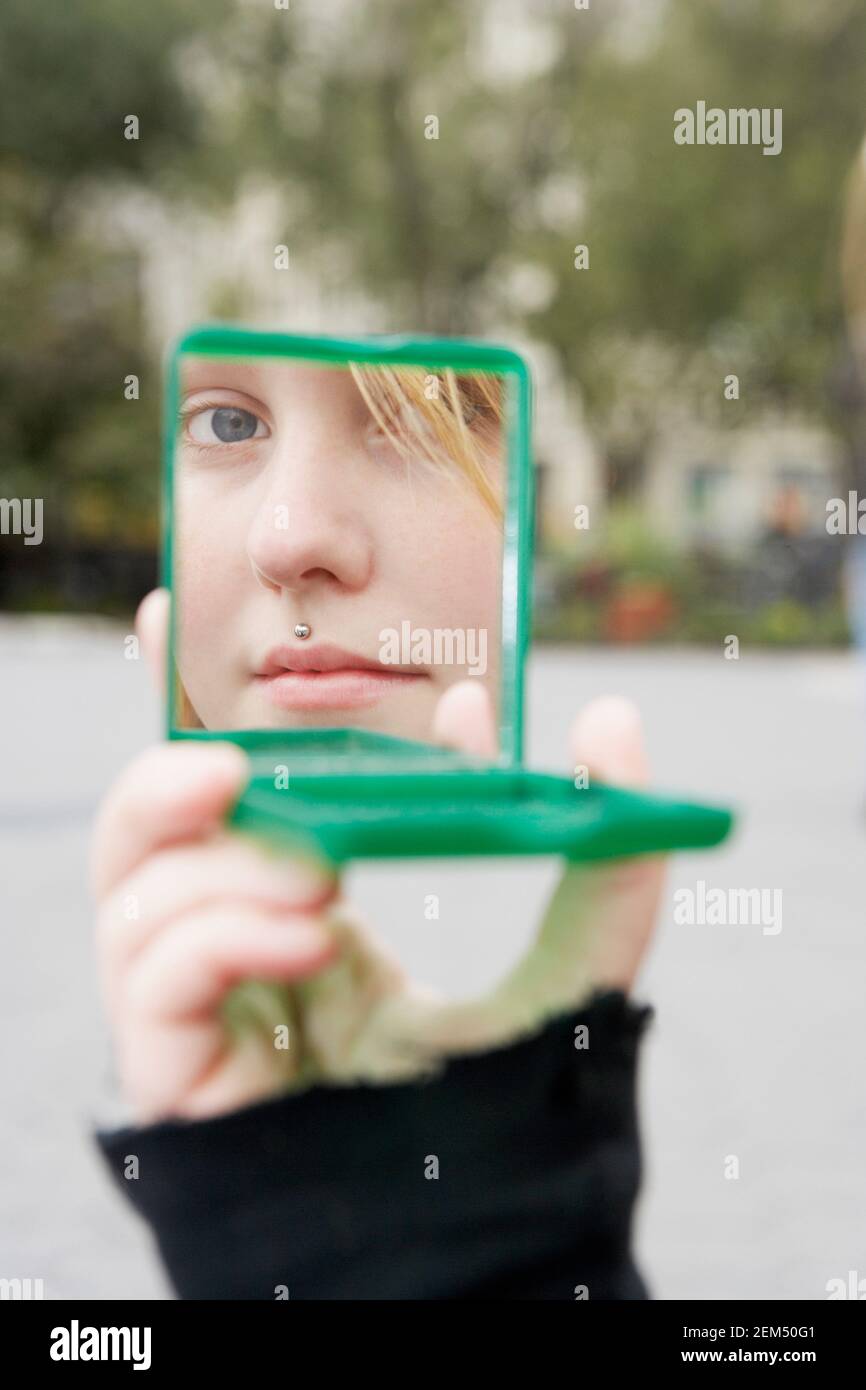 Reflection of a young woman in a hand mirror Stock Photo