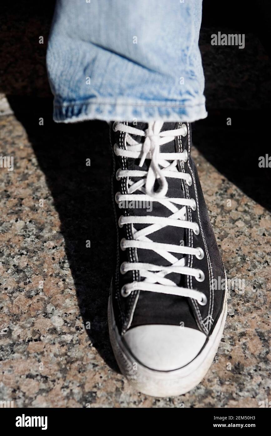 High angle view of a person's leg wearing canvas shoe Stock Photo - Alamy