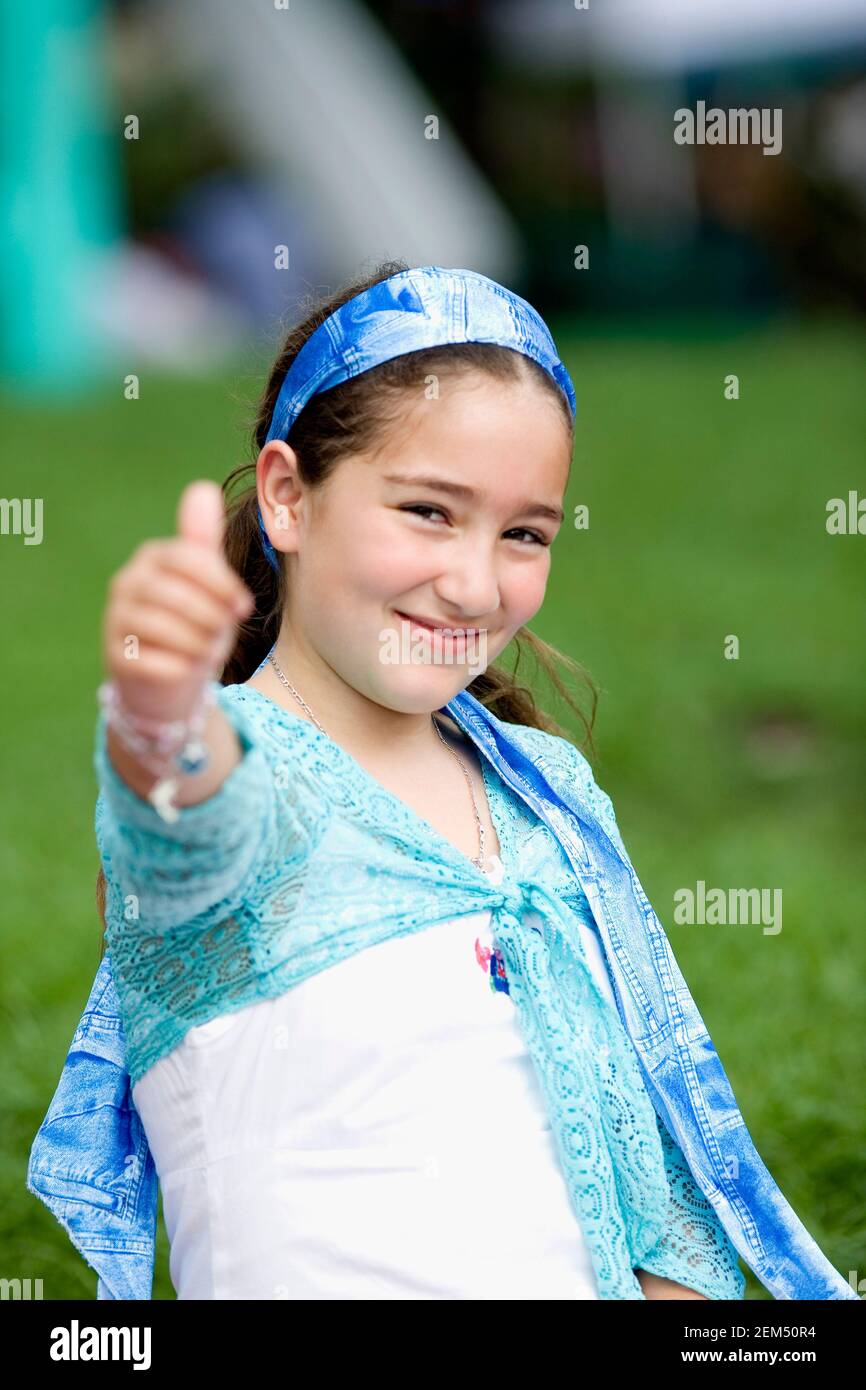Portrait of a girl showing a thumbs up sign Stock Photo - Alamy