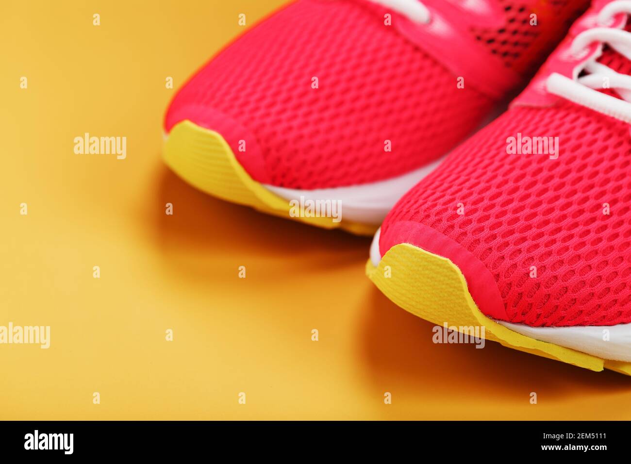 Sports sneakers, pink on a yellow background with free space. Top view ...