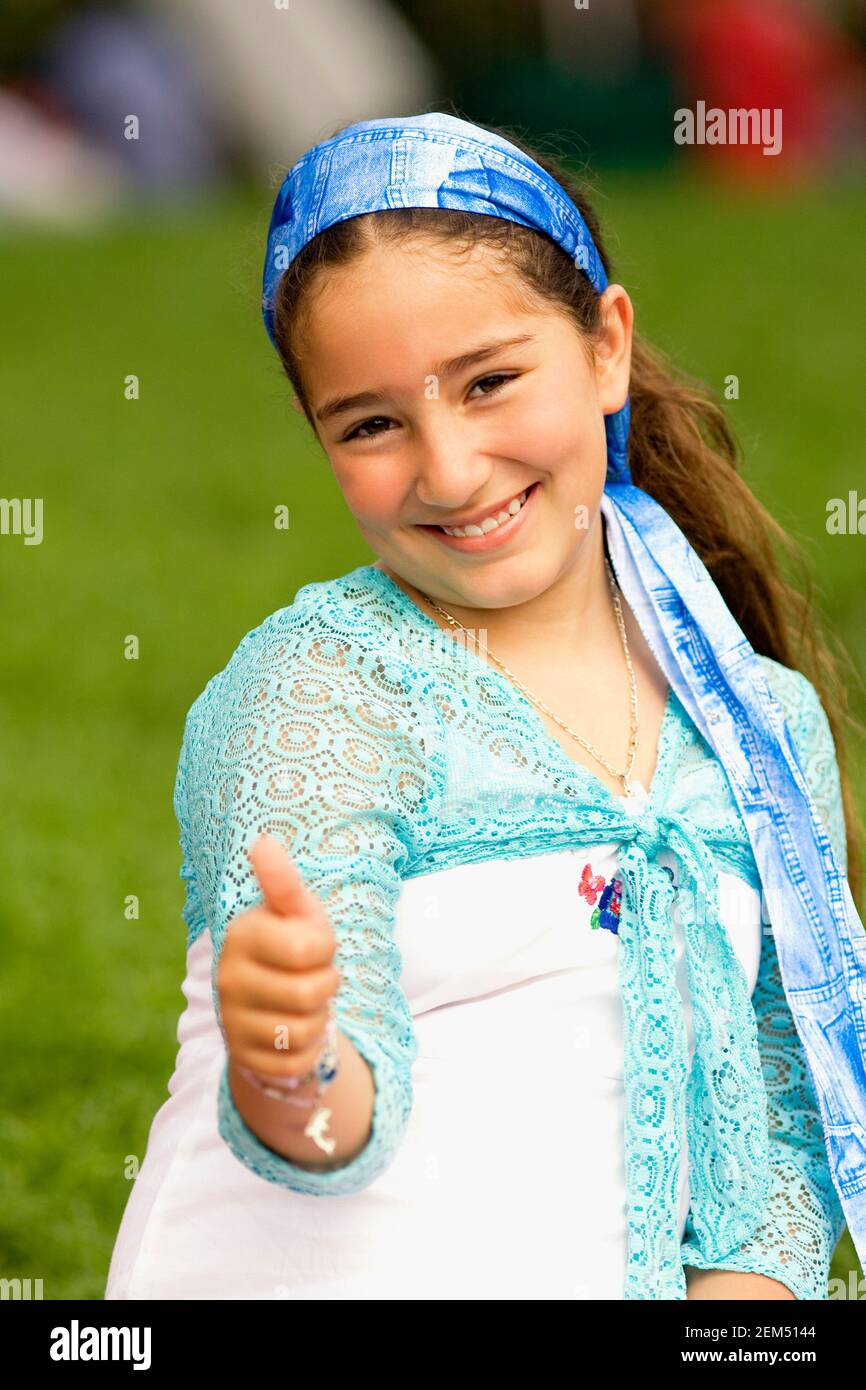Portrait of a girl showing a thumbs up sign Stock Photo - Alamy