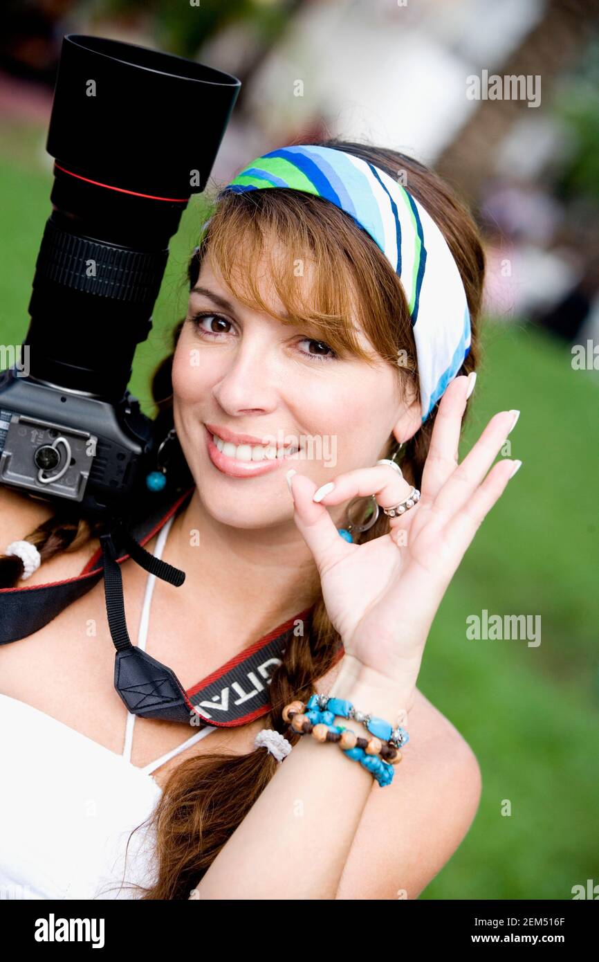 Portrait of a young woman holding a camera and smiling Stock Photo