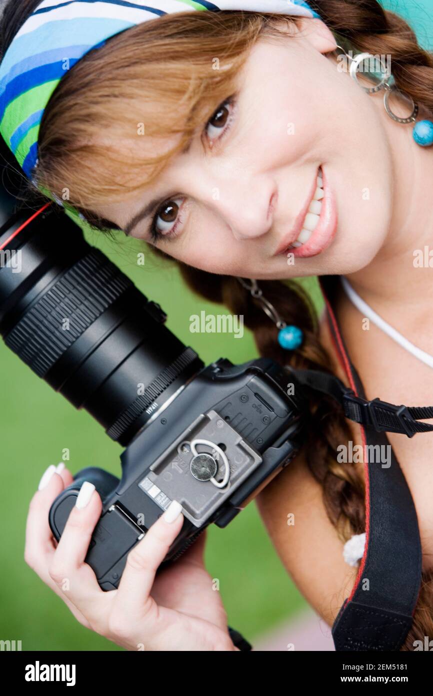 Portrait of a mid adult woman holding a camera Stock Photo
