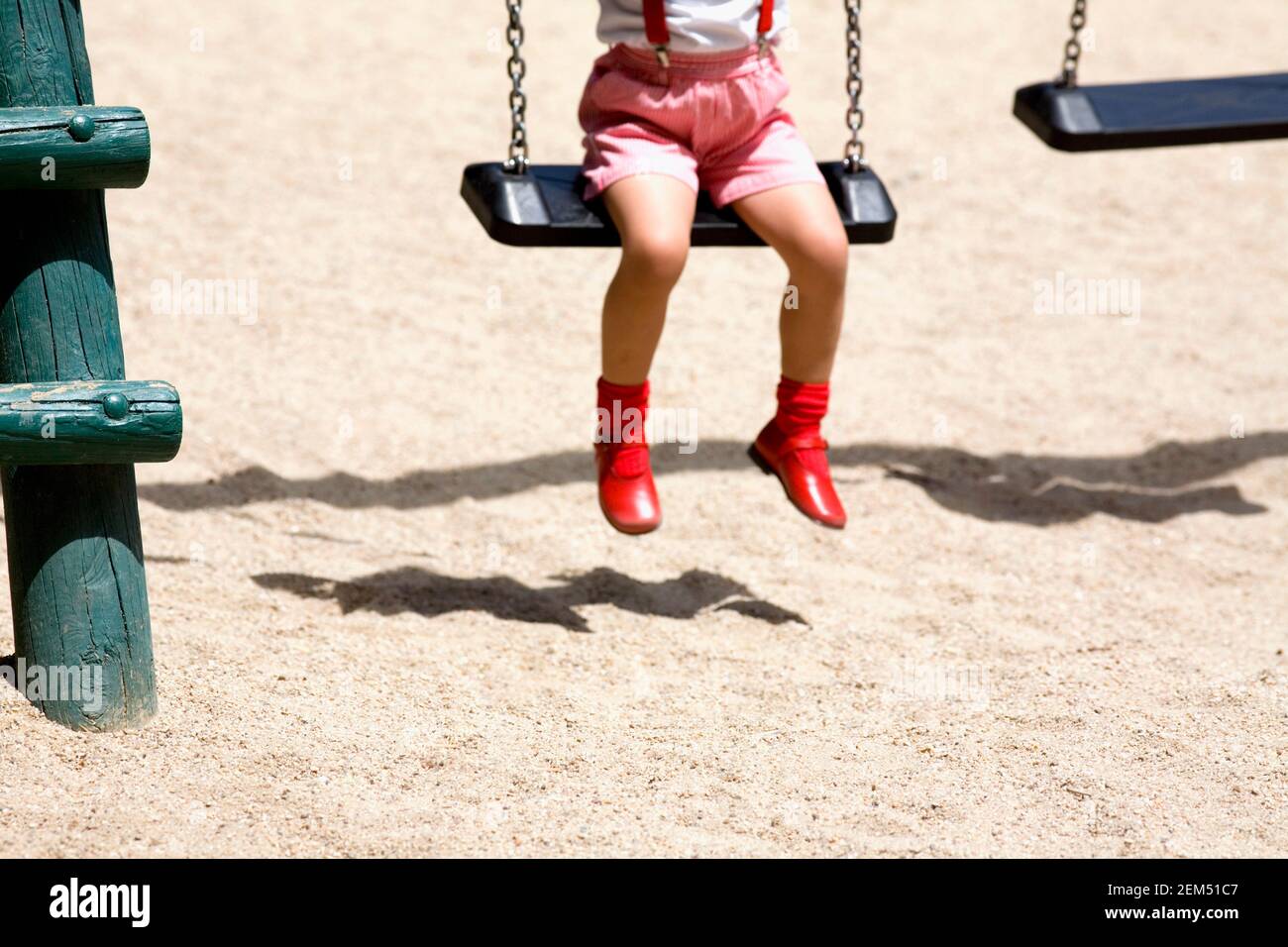 Low section view of a girl sitting on a swing Stock Photo - Alamy
