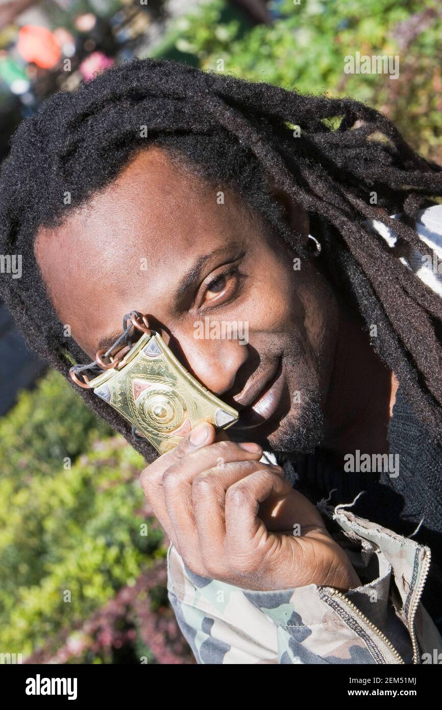 Portrait of a young man covering his eye with a buckle Stock Photo - Alamy