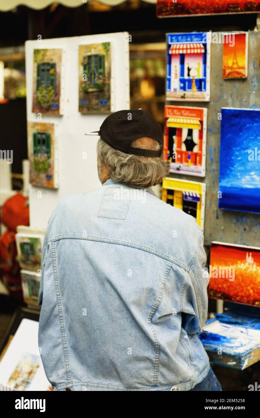 Rear view of a person standing in front of paintings Stock Photo