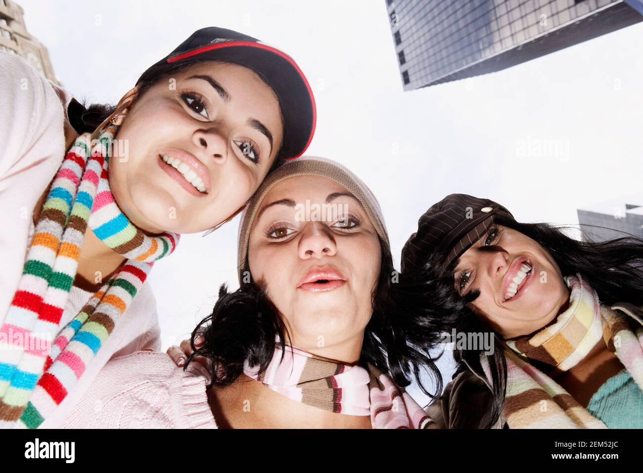 Low angle view of two young women and a mid adult woman smiling Stock Photo