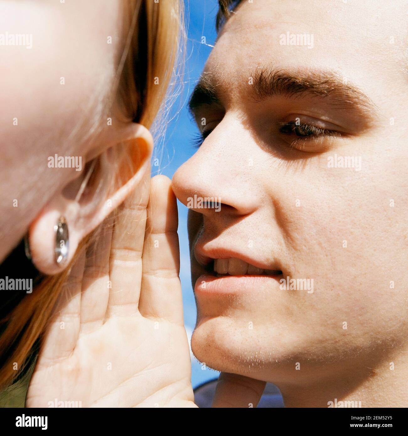 Man Whispering In Womans Ear