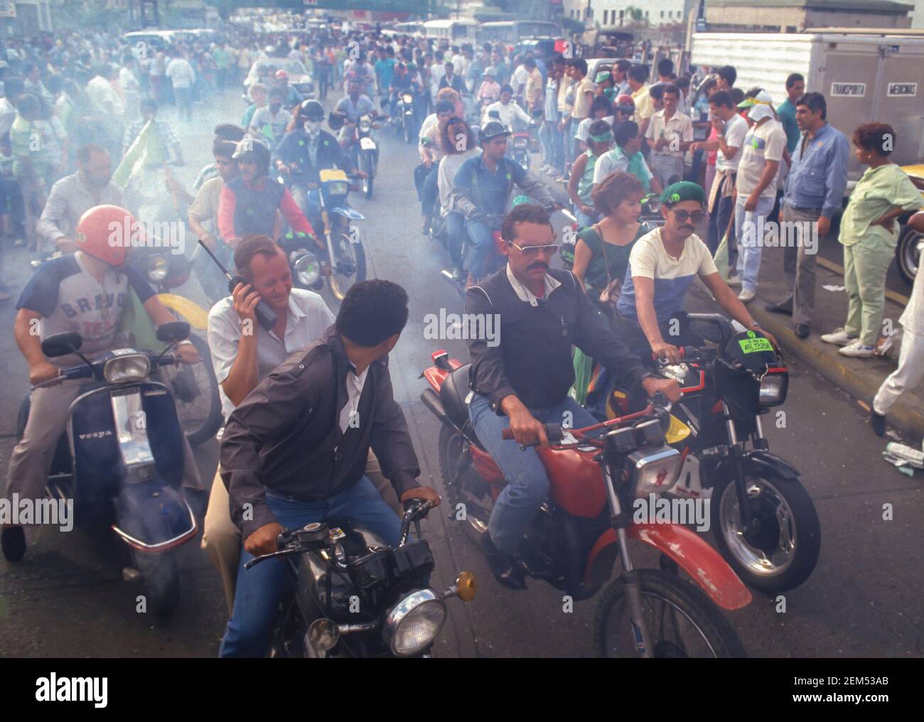 CARACAS, VENEZUELA, 1988 - Exhaust smoke pollution from crowd of motorbikes, also known as motos or scooters, in downtown Caracas. Stock Photo