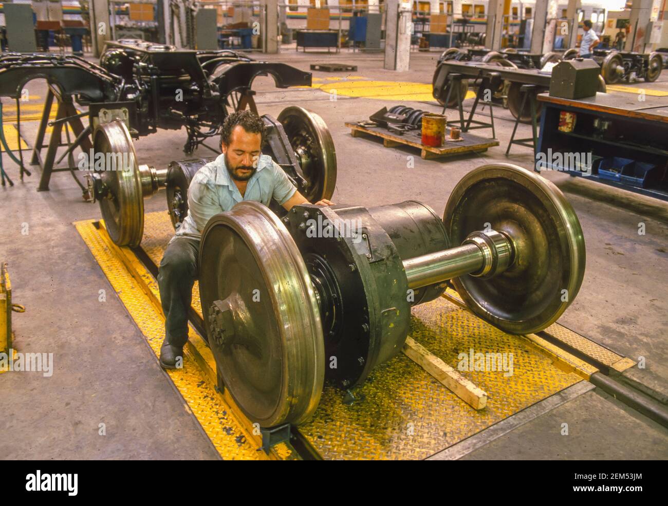 CARACAS, VENEZUELA, 1988 - Man works on train wheels at Metro train repair and maintanance shop. Stock Photo