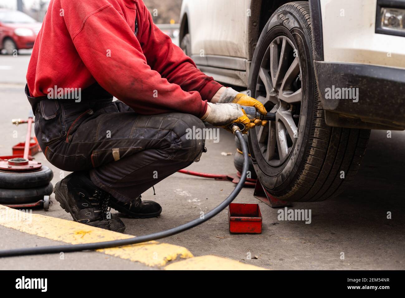 Car mechanic removing wheel nuts to check brakes Stock Photo Alamy