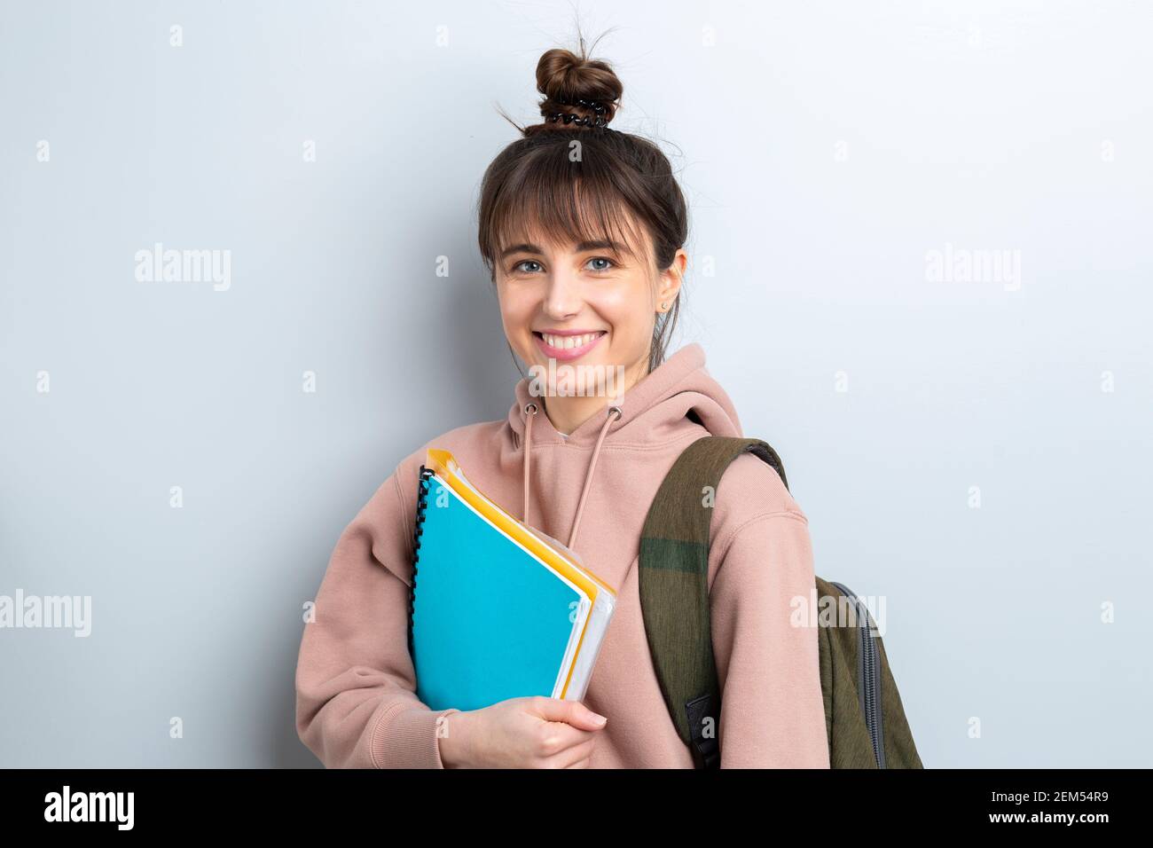 Portrait of a happy girl student with books in a hoodie. Smiling young ...
