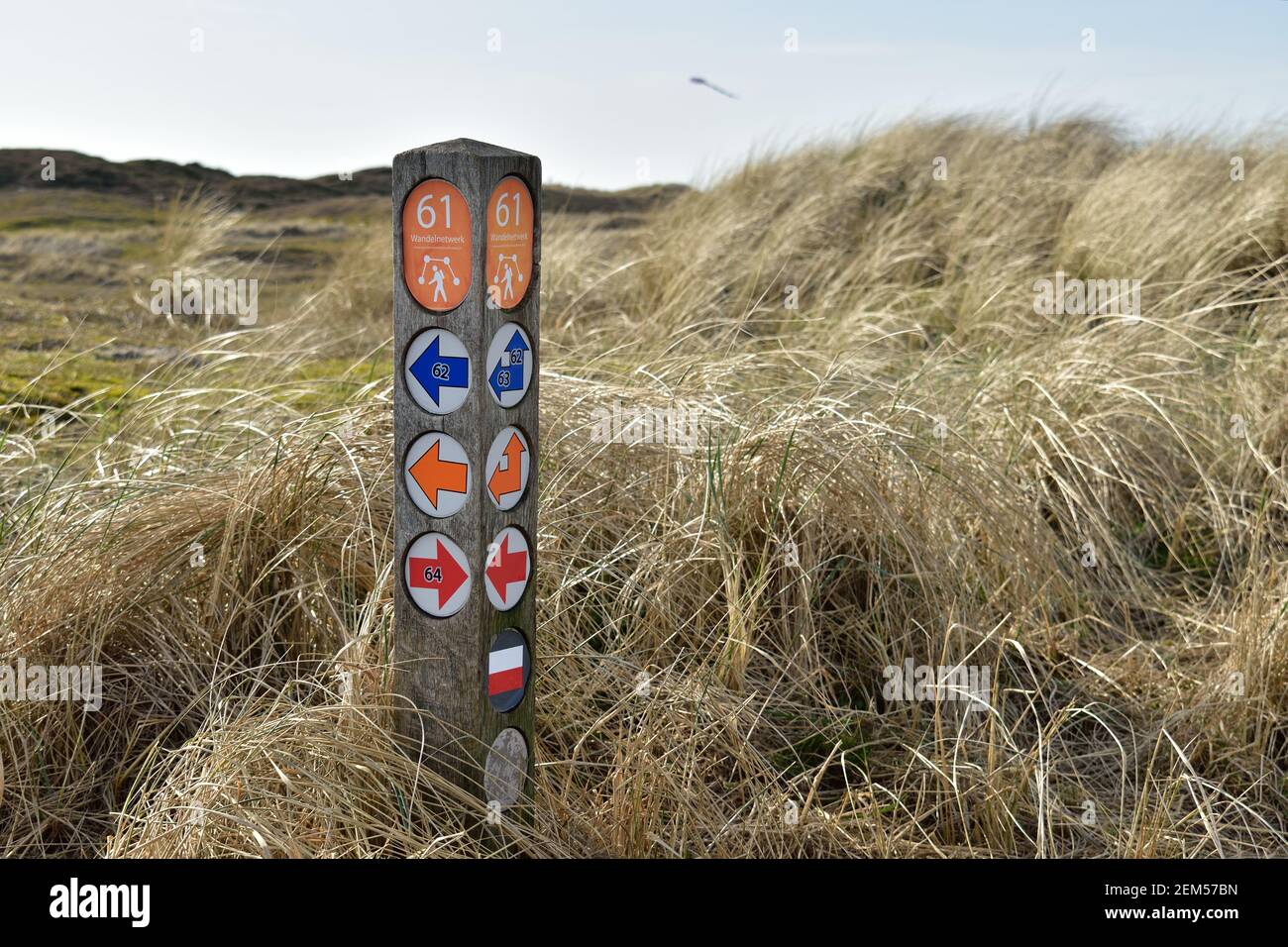 Hiking trail marker post in the sand dunes with meaning