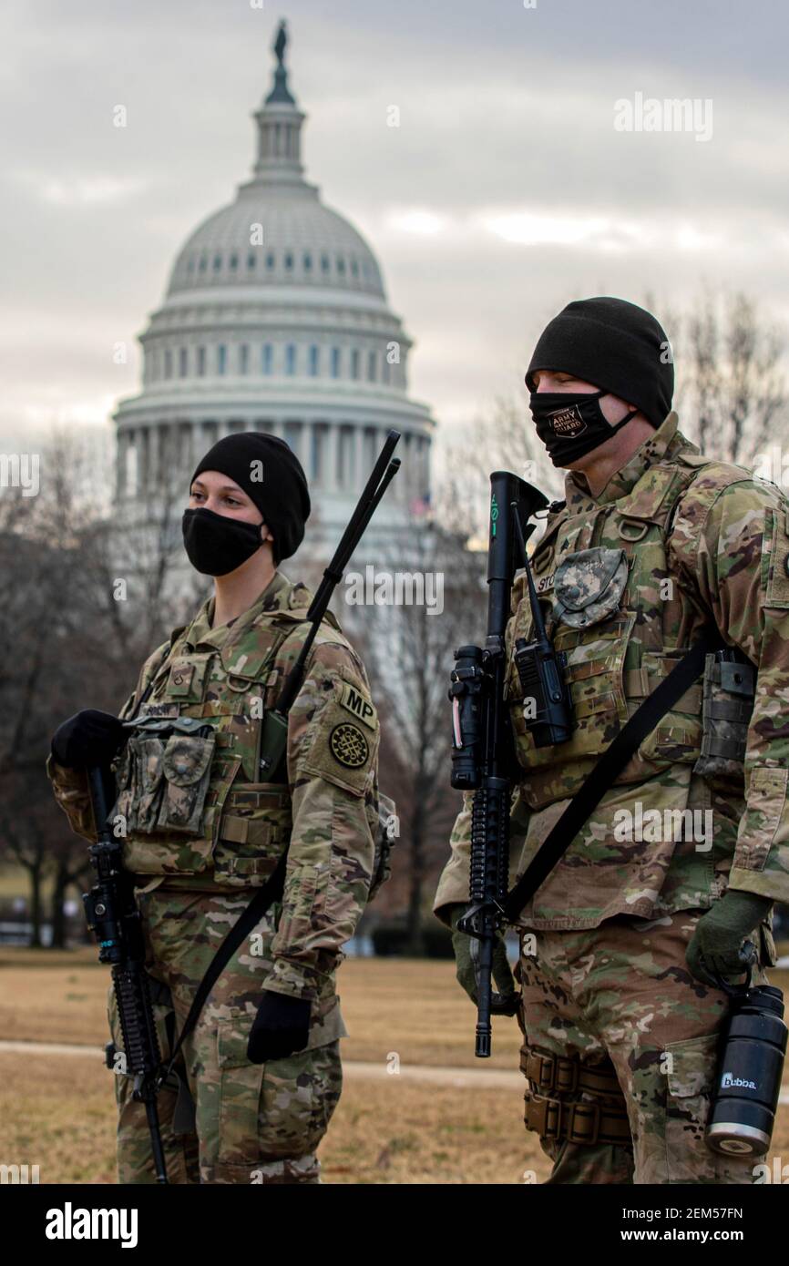 Washington, United States. 23rd Feb, 2021. U.S. Army Pfc. Rebekah Bouman, left, and Sgt. Benjamin Stroll, both military policemen with the 46th Military Police Company, stand watch near the U.S. Capitol February 23, 2021 in Washington, DC The National Guard will continue supporting federal law enforcement agencies with security around the Capitol until the end of March. Credit: Planetpix/Alamy Live News Stock Photo