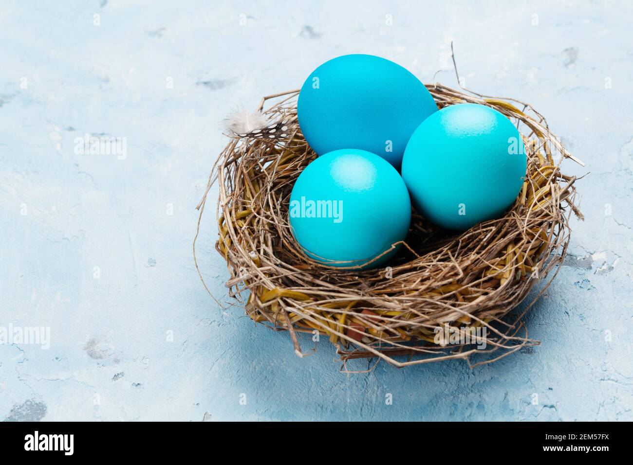 Colorful easter eggs in nest on stone background. With space for your ...