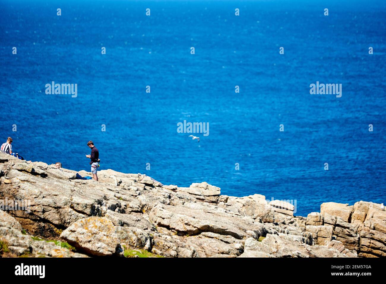 People walk the South West Coast Path from Sennen Cove towards Land's End in Cornwall during summer Stock Photo